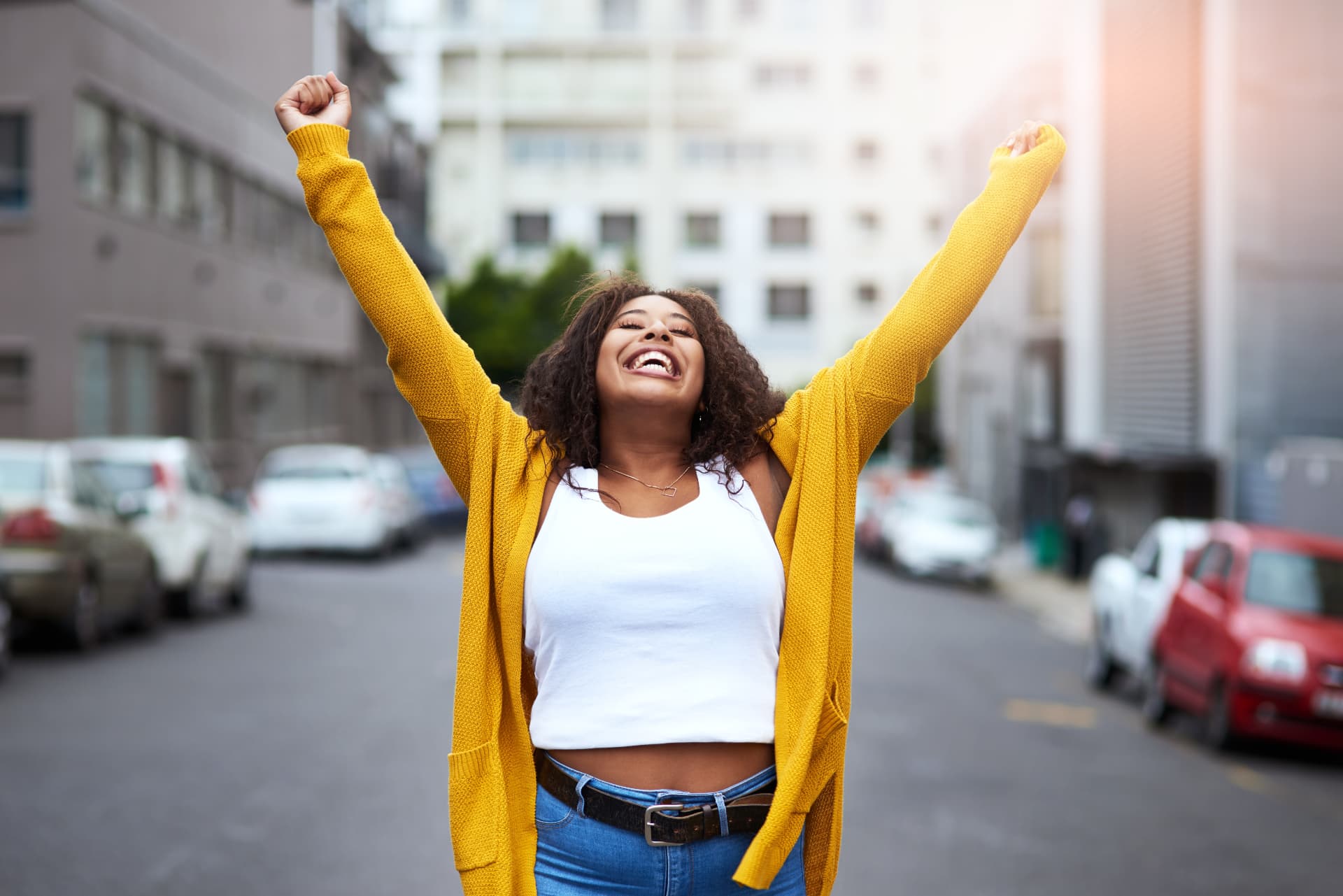 Woman celebrating with arms raised in the street